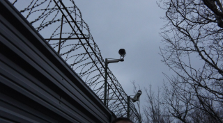 Tkachev's fence outfitted with new video cameras. (Photo: Bellona/EWNC/Greenpeace)